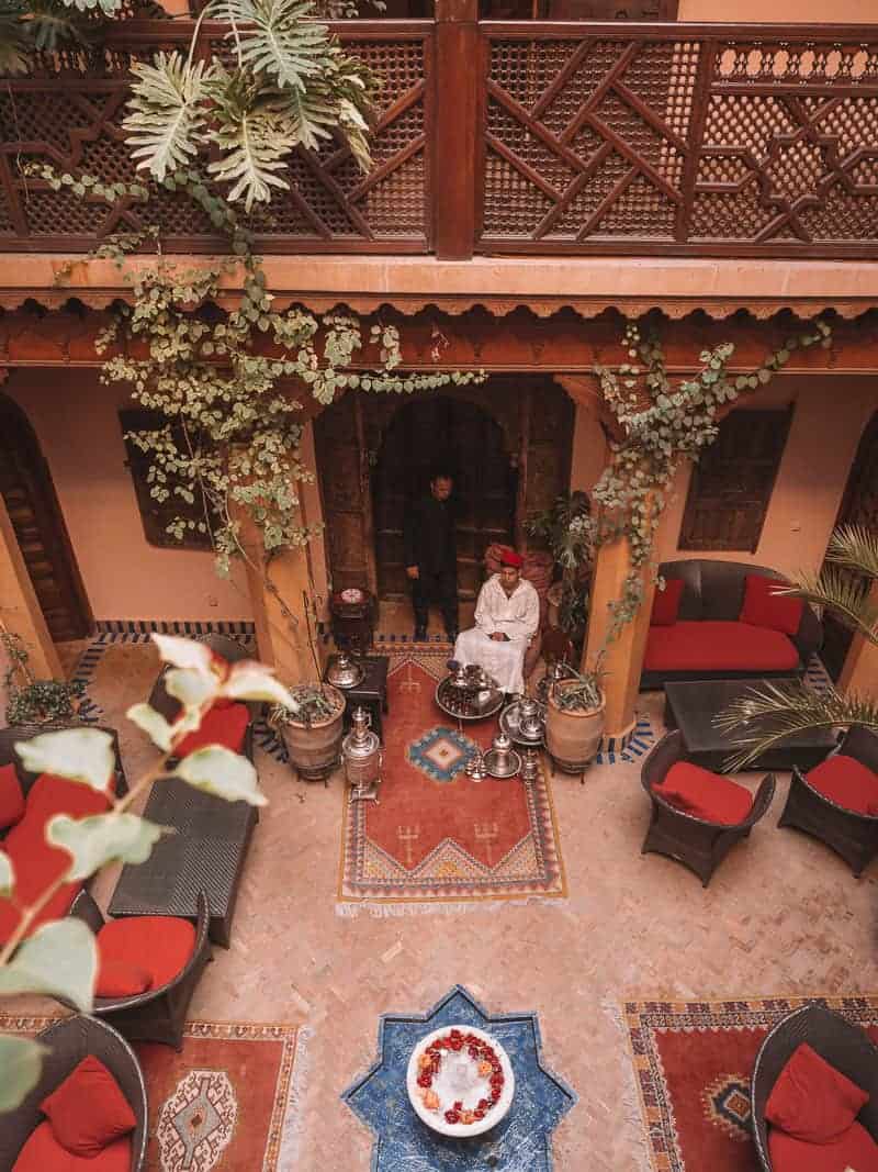 A boy serving tea and cookies in the courtyard of a Moroccan Riad Hotel.