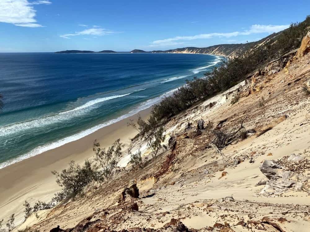Standing on top of the coloured sands of rainbow beach with views out to the ocean