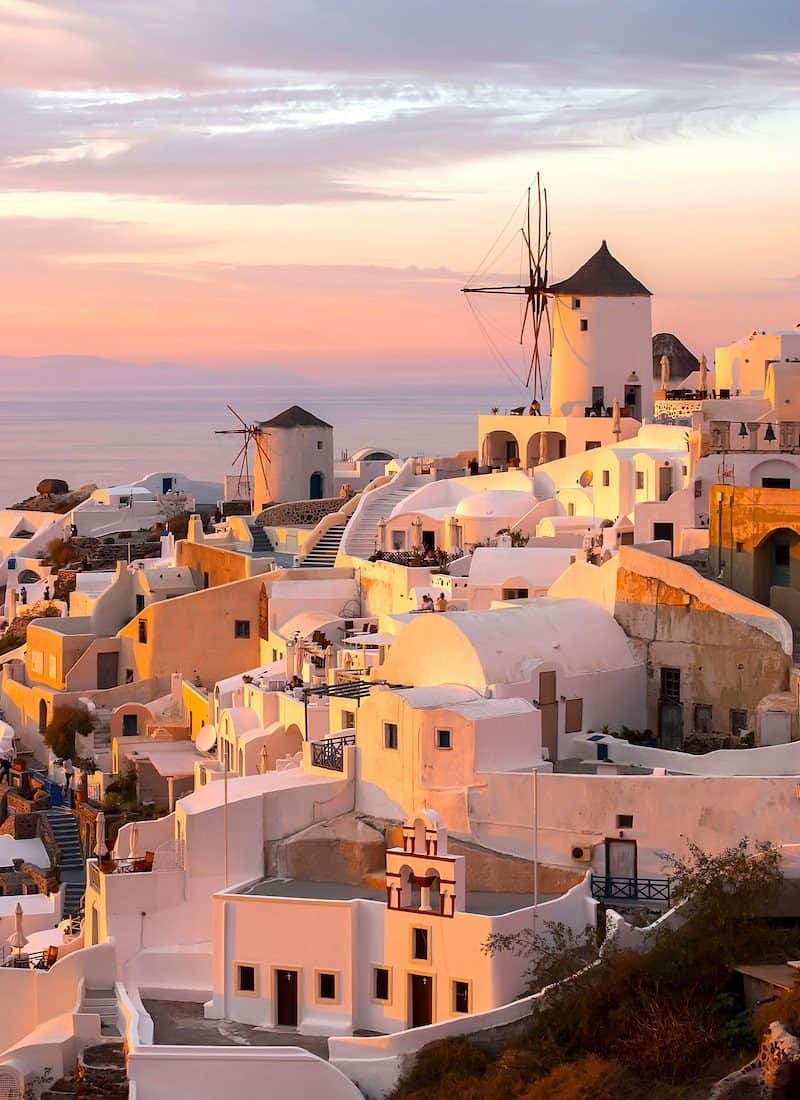 Oia Santorini buildings lit up in pink at sunset
